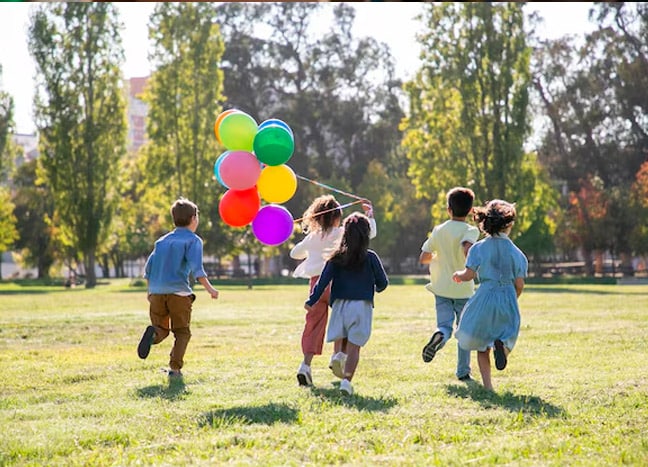 niños en el parque jugando globo